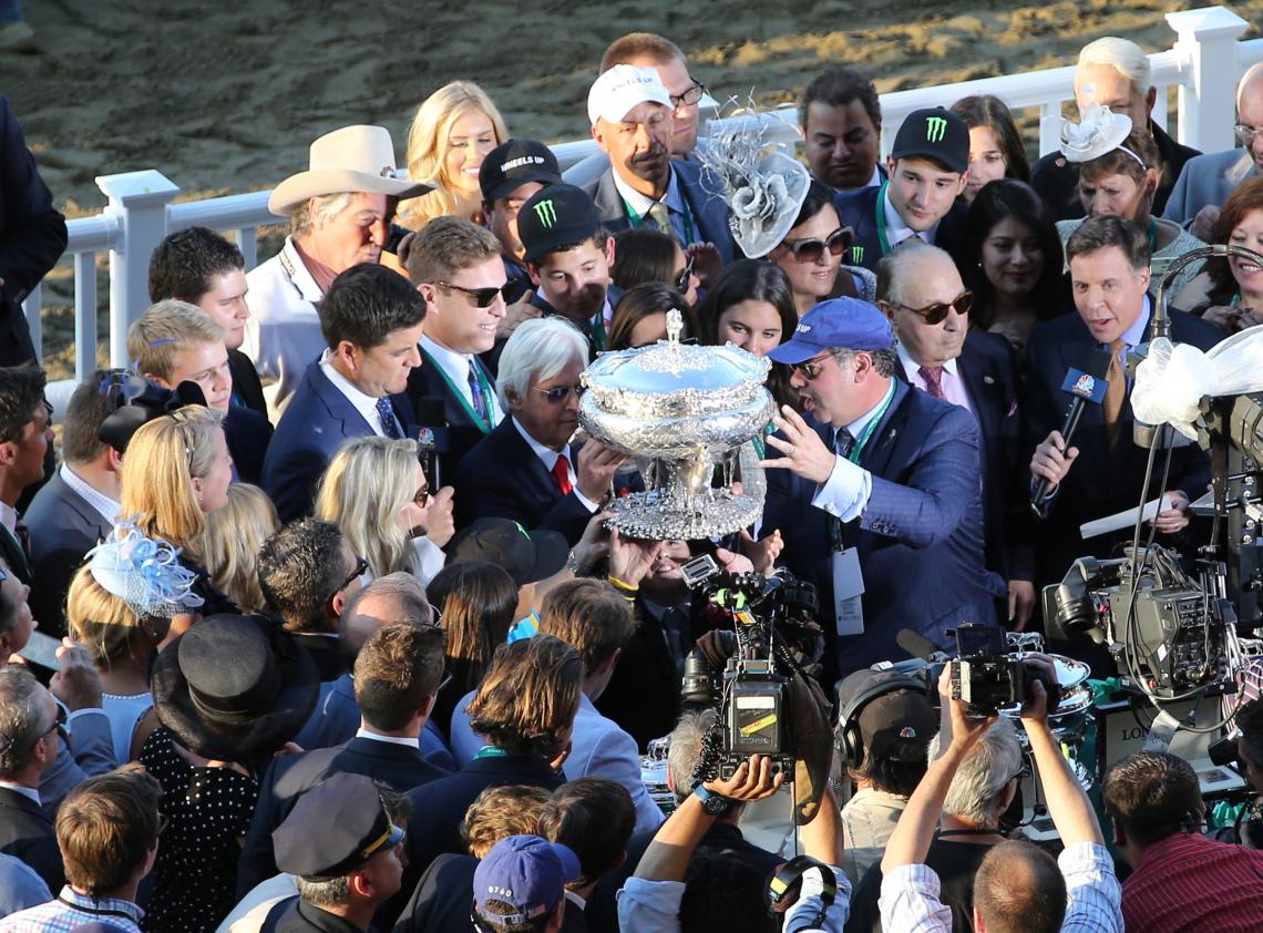 Surrounded by media, trainer Bob Baffert and owner Ahmed Zayat hoist the trophy after their horse, American Pharoah, won the Belmont Stakes on Saturday. Surrounded by media, trainer Bob Baffert and owner Ahmed Zayat hoist the trophy after their horse, American Pharoah, won the Belmont Stakes on Saturday.